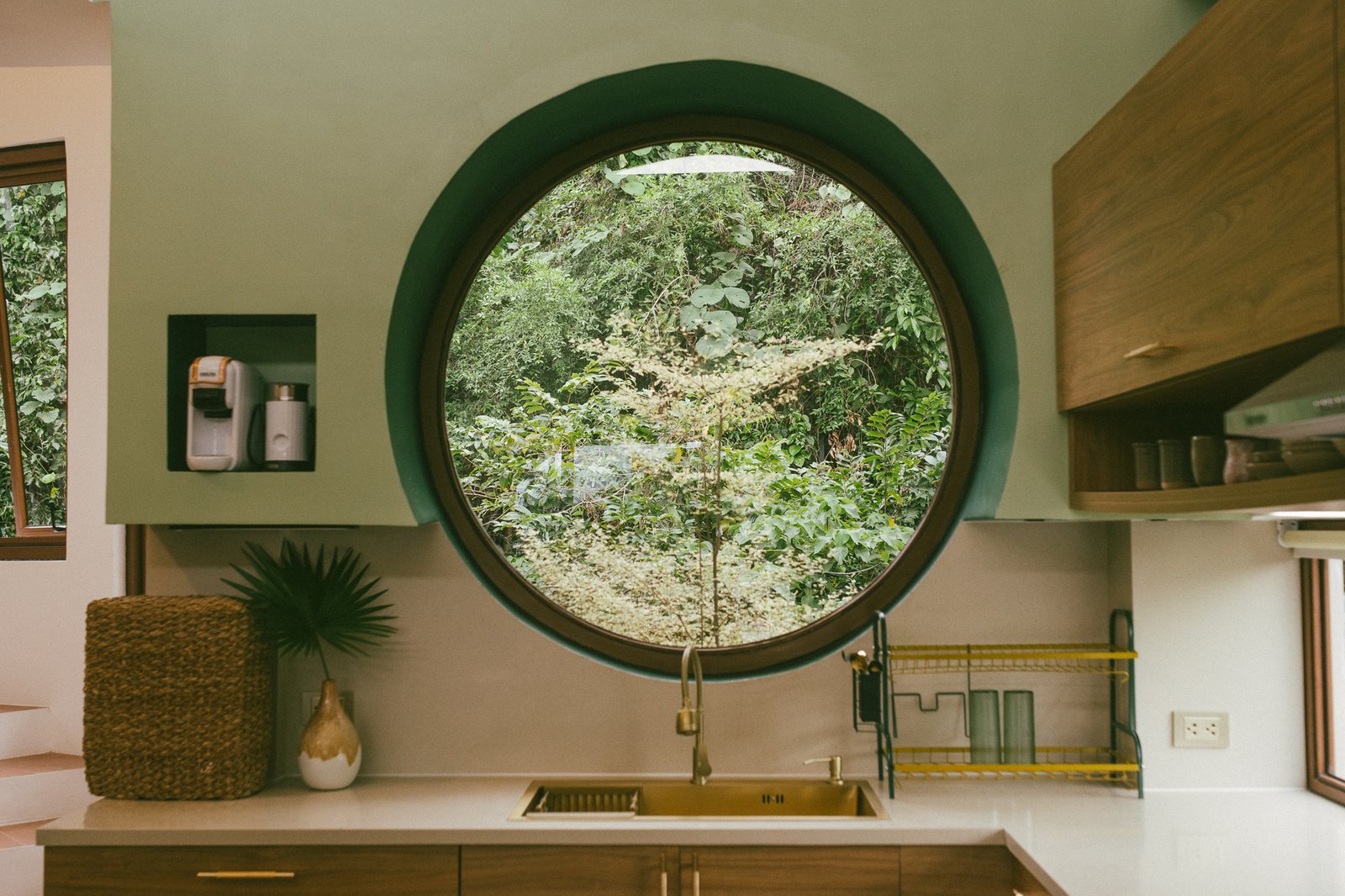 Round window over the kitchen sink with jungle view